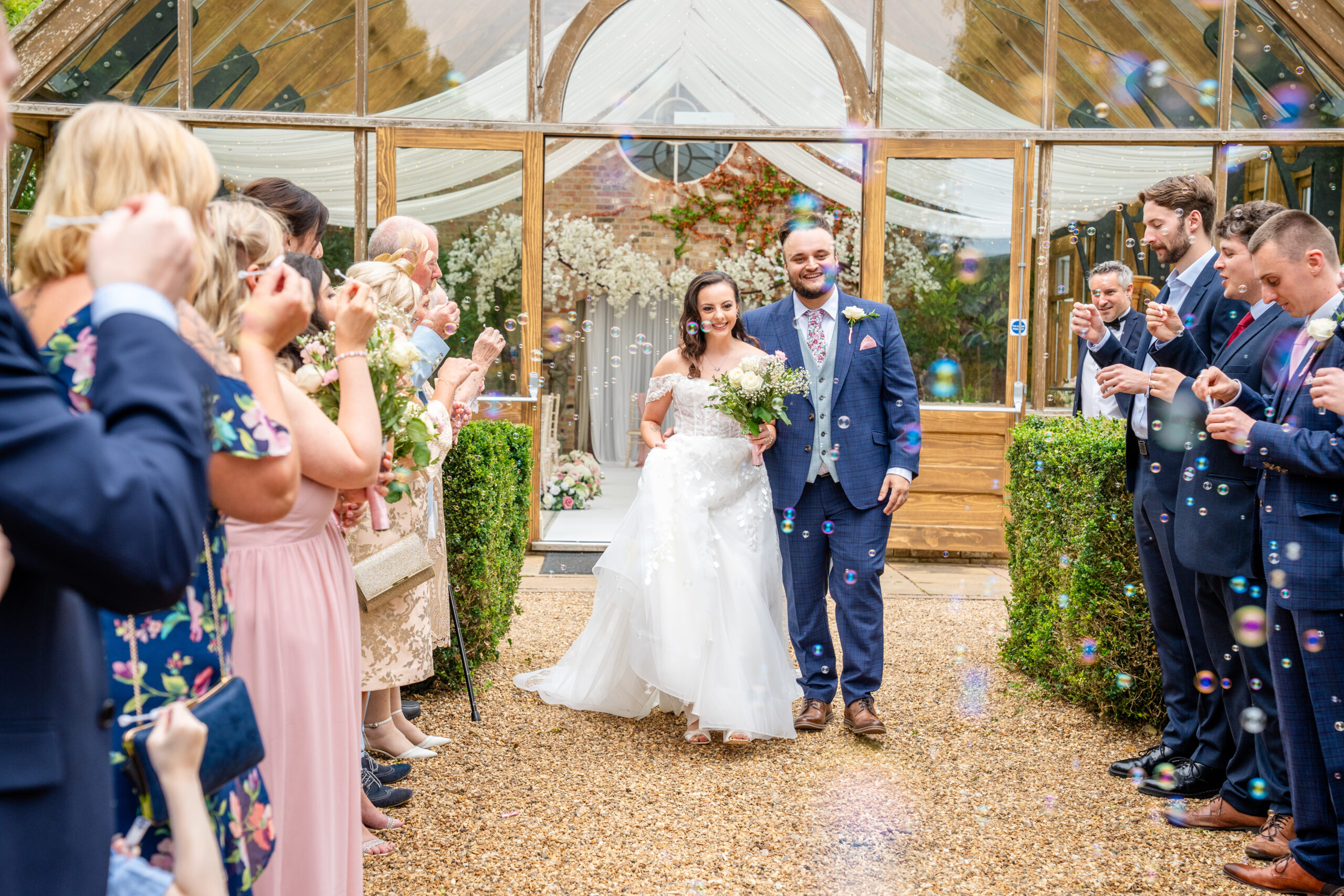 Couple portraits with bubbles in the grounds of Hanbury Manor wedding venue in Hertfordshire 