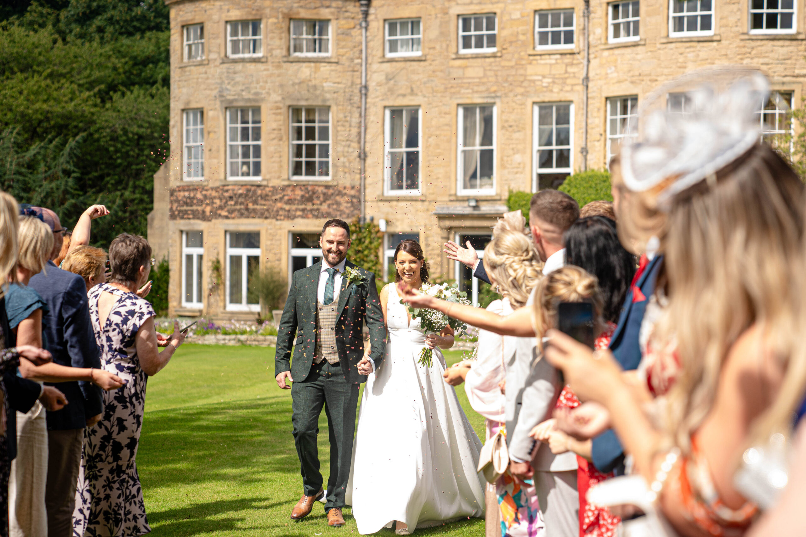 Confetti exit with the house in the backgroundcaptured by Hooton Pagnell Wedding Photographer 