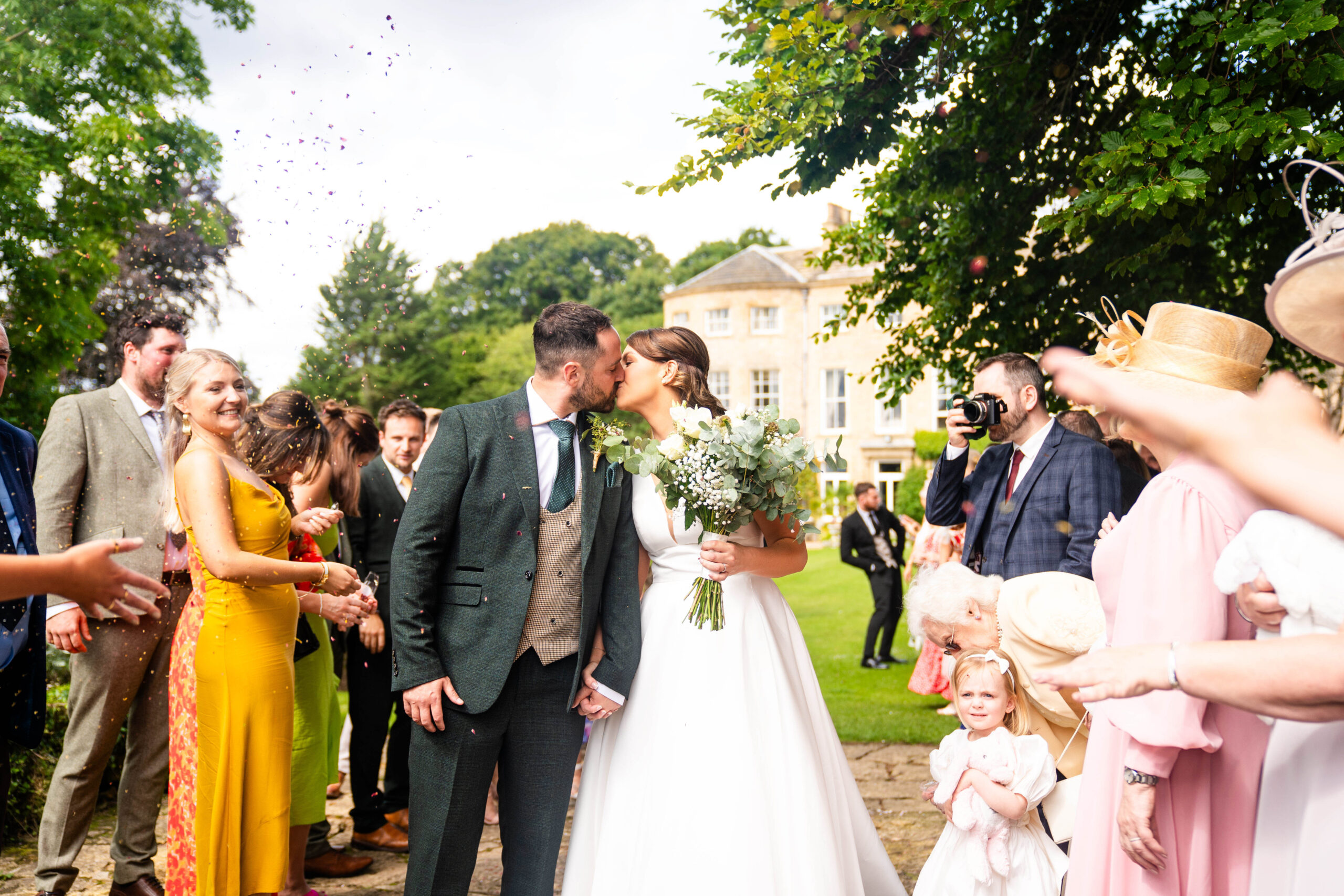 Confetti exit with the house in the background captured by Hooton Pagnell Hall Wedding Photographer 